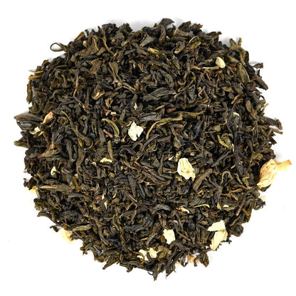 Close up of dry green tea leaves with light yellow and white tinted flower pedals.