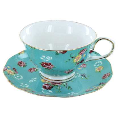 Turquoise porcelain teacup and saucer with floral design on a white background