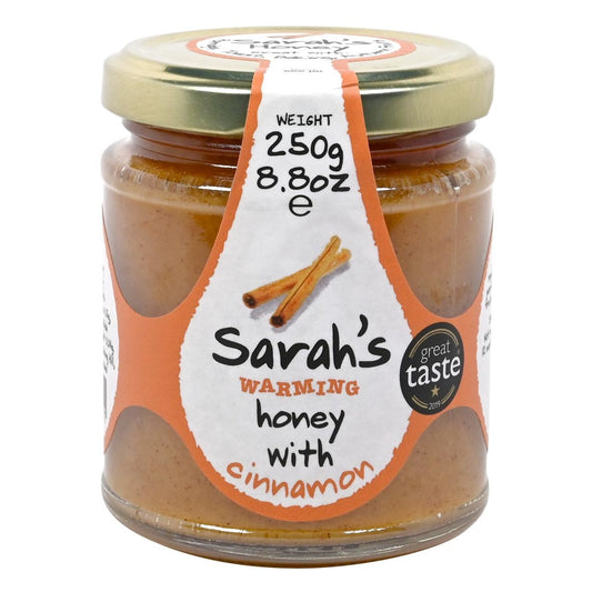 Jar of Sarah's warming honey with cinnamon on a white background
