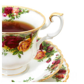 A filled floral teacup and a saucer