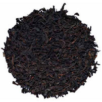 A closeup pile of dry, black loose leaf tea.