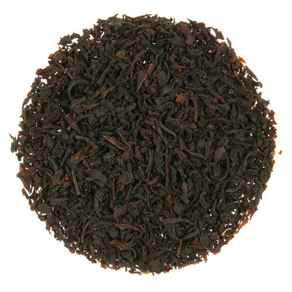 Close-up of dark brown tea leaves on a white background