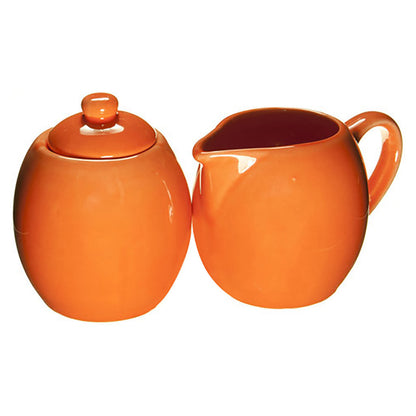 Orange ceramic sugar bowl and creamer set on a white background