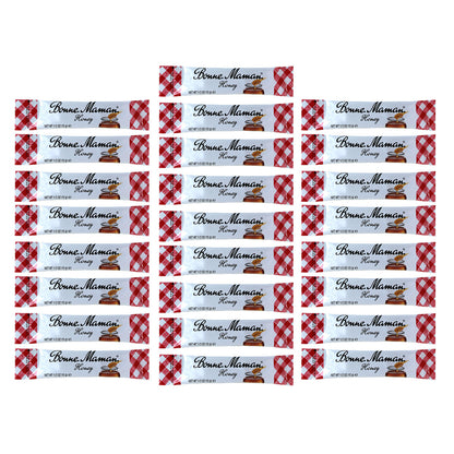 Numerous packets of Bonne Maman honey with a red and white checkered design on the packaging.