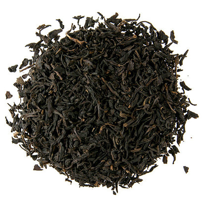 Close-up of dark brown tea leaves on a white background