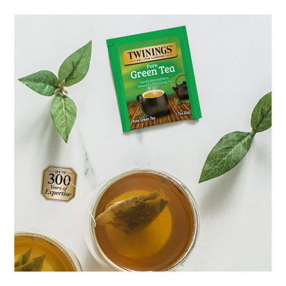 Twinings Pure Green Tea packet with a cup of tea and tea leaves on a white background