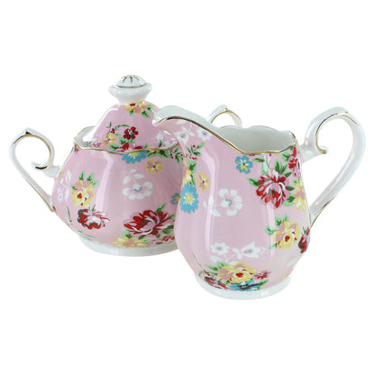 Floral-patterned porcelain sugar bowl and creamer set on a white background