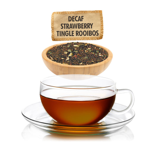 Decaf Strawberry Tingle Rooibos tea with a glass cup of tea and a wooden bowl of tea leaves on a white background.