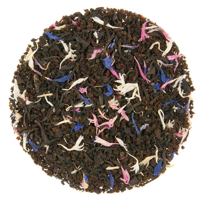 Dry black tealeaves with blue, peak, and off-white flower petals.