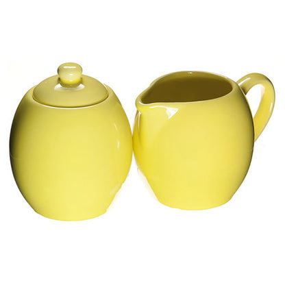 Yellow ceramic sugar bowl and creamer set on a white background