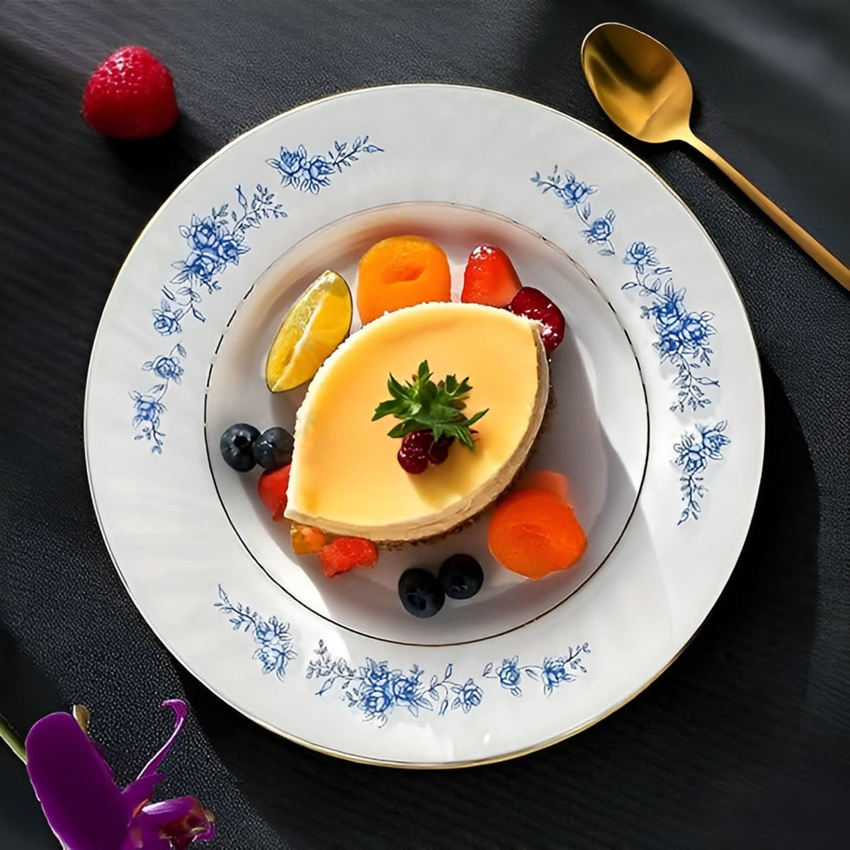 Delicate dessert with fruit on a decorative plate with floral patterns, set against a dark background.