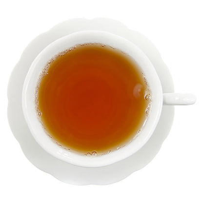 Light amber colored hot tea in white cup on white background