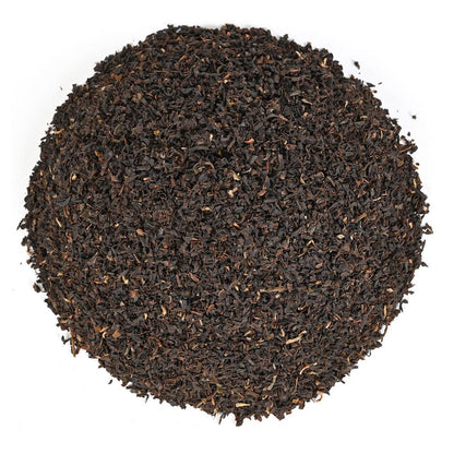Close-up of dark brown tea leaves on a white background