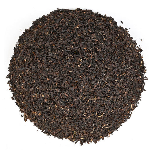 Close-up of dark brown tea leaves on a white background