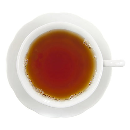 Hot amber colored tea in a white teacup and saucer on a white backround